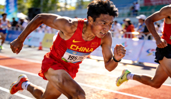中国马拉松运动员在比赛中冲刺的瞬间，表情专注坚毅